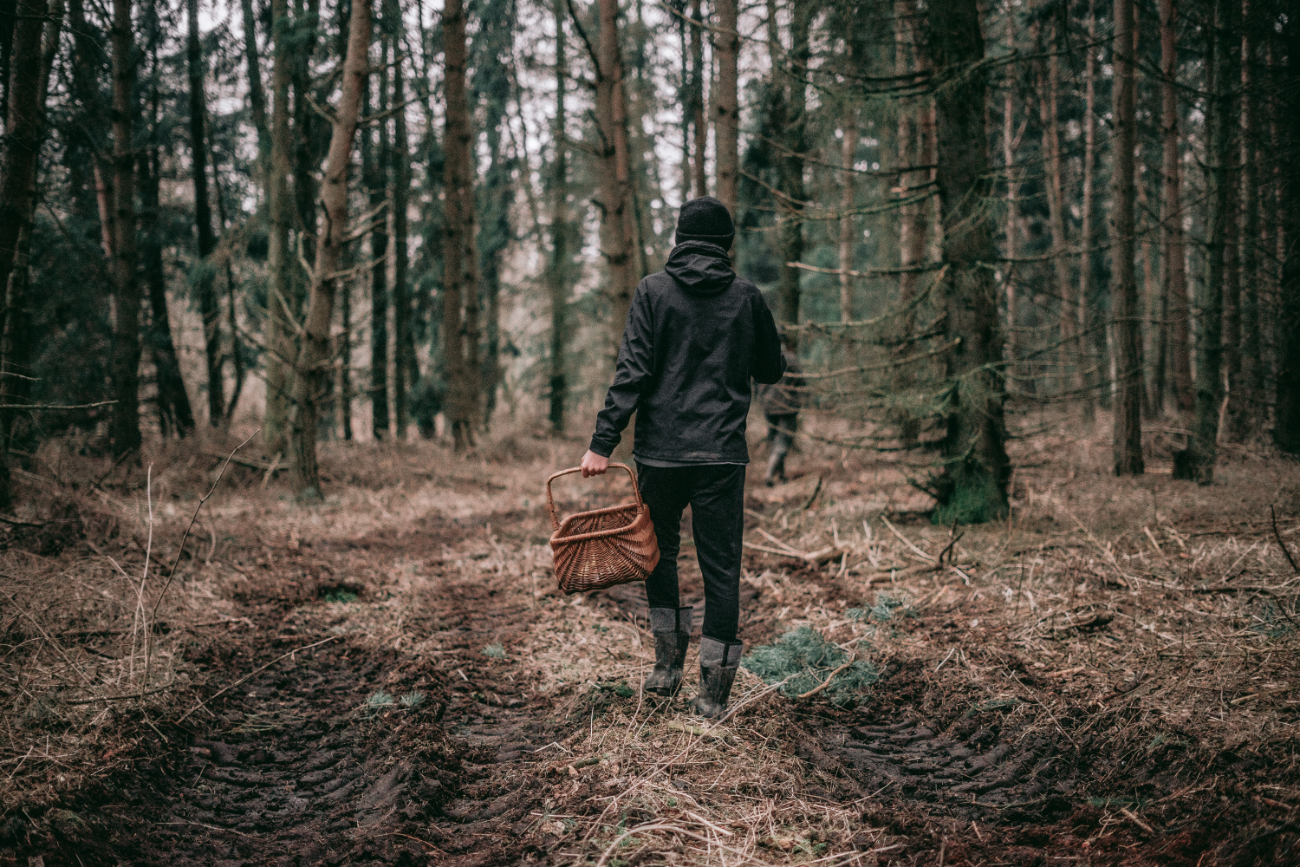 man walking in the woods with basket
